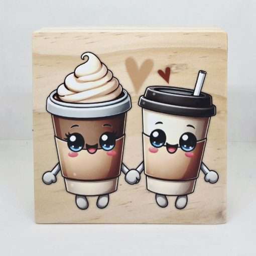 Coffee Cup Sweethearts Sign featuring two cute smiling coffee cups holding hands with hearts above them on a natural pine wooden desk sitter displayed in a cosy coffee bar setting.