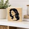 Elegant Lady Shelf Sitter featuring a black silhouette of a woman with long flowing hair on a natural wooden block displayed on a decorative shelf.