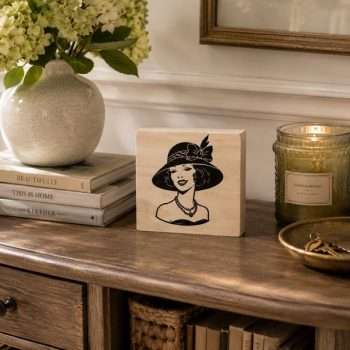 Vintage Lady Wooden Sign featuring a stylish woman wearing an elegant bow-trimmed hat, displayed on a wooden entryway table with flowers, books and a candle. 6